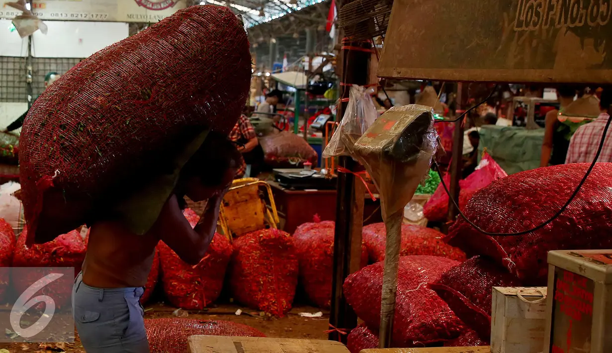 Seorang buruh mengangkut sekarung cabe di kawasan Pasar Induk Kramat Jati, Jakarta, Sabtu (14/01). Rata-rata mereka mendapatkan upah Rp 30.000 - Rp 50.000 ribu dari setiap jasa pengantaran. (Liputan6.com/JohanTallo)