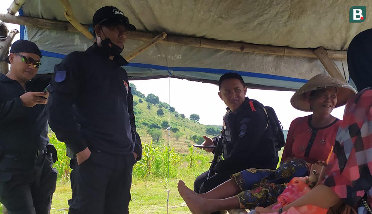 Petani jagung membaur dengan petugas Brimob yang berjaga sejak Selasa (15/3/2022) di bukit Pongos di area Sirkuit Internasional Mandalika. (Bola.com/Wiwig Prayugi)