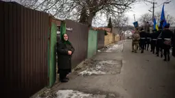 Olha Petrenko (84) menangis saat peti mati Oleksandr Maksymenko (38) lewat pada pemakamannya di kampung halamannya di Kniazhychi, sebelah timur Kyiv, Ukraina, 13 Februari 2023. Oleksandr Maksymenko, seorang warga sipil yang menjadi sukarelawan di angkatan bersenjata Ukraina, tewas dalam pertempuran di daerah Bakhmut. (AP Photo/Emilio Morenatti)