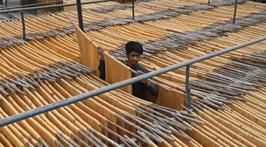 Seorang pekerja mengeringkan bihun yang digunakan untuk membuat hidangan manis tradisional yang populer selama bulan puasa Ramadhan di Lahore, Pakistan, 12 April 2022. (Arif ALI/AFP)