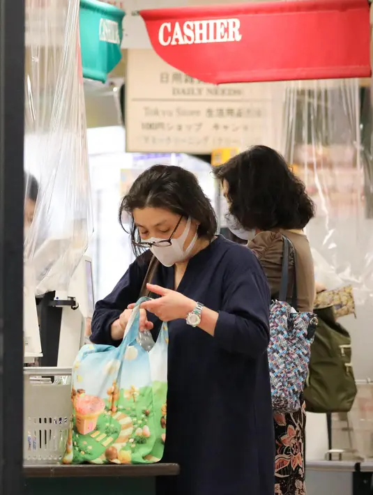 Seorang pelanggan menggunakan tas belanja sendiri untuk membawa barang-barang di sebuah toko di Tokyo, Jepang, pada 1 Juli 2020. Pemerintah menerapkan kebijakan ini sebagai langkah untuk menekan penggunaan kantong plastik yang berlebihan dan melindungi lingkungan. (Xinhua/Du Xiaoyi)