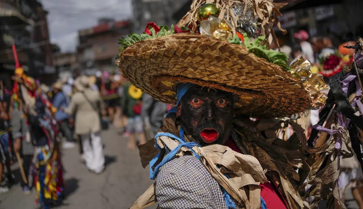 Seorang pria berpakaian bolero berpose selama perayaan Hari Orang Suci di Caucagua, Venezuela, Selasa (28/12/2021). Tradisi berusia lebih dari 200 tahun adalah hari nyanyian, tarian, dan lelucon. (AP Photo/Matias Delacroix)