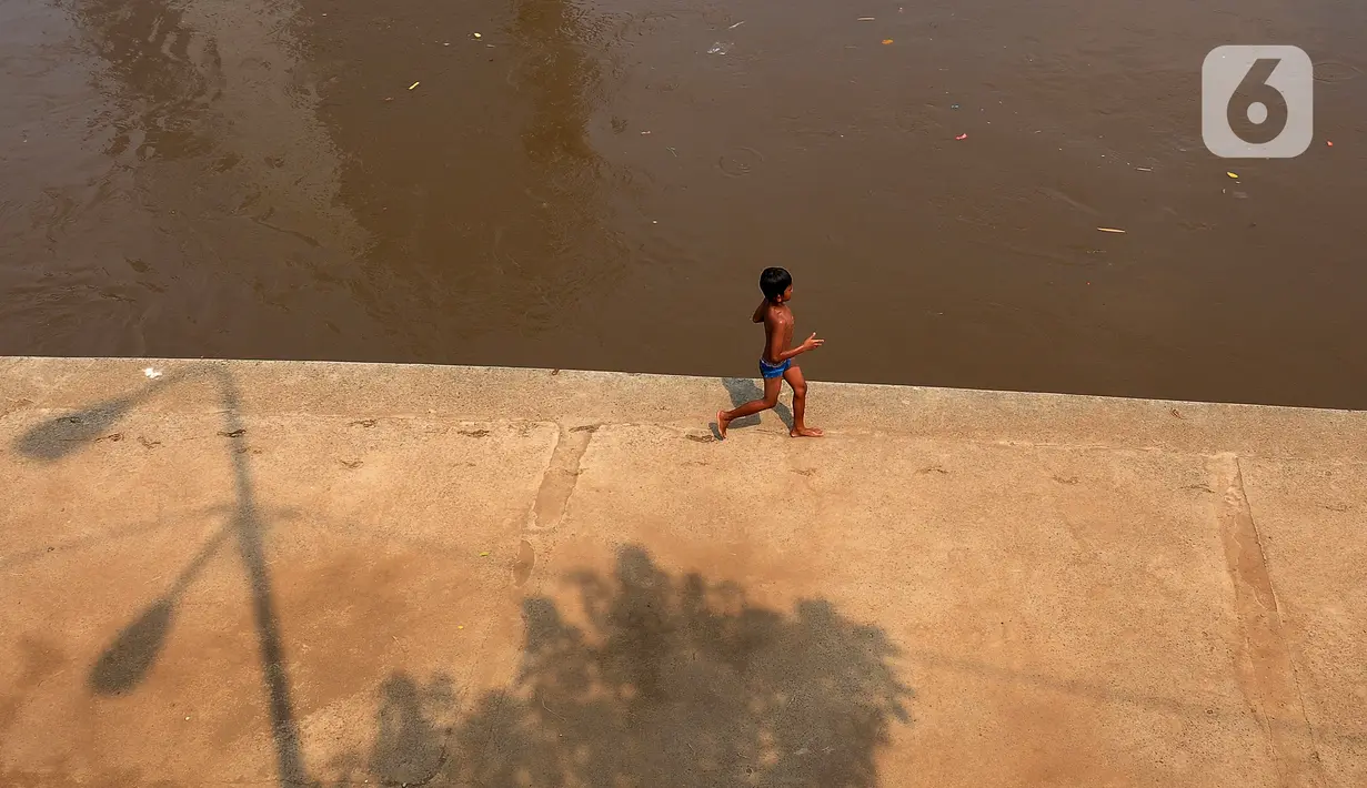 Sejumlah anak-anak bermain di aliran Kali Ciliwung, Cawang, Jakarta, Kamis (16/11/2023). Awal musim hujan 2023/2024 di Indonesia diperkirakan mulai pada Oktober hingga Desember 2023. (merdeka.com/Imam Buhori)
