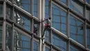 Alain Robert yang dijuluki 'French Spiderman' memanjat gedung pencakar langit Cheung Kong Center di Hong Kong, Jumat (16/8/2019). Pria berusia 57 tahun tersebut memanjat Cheung Kong Center dalam kondisi panas dan lembab pada Jumat pagi. (Lillian SUWANRUMPHA/AFP)
