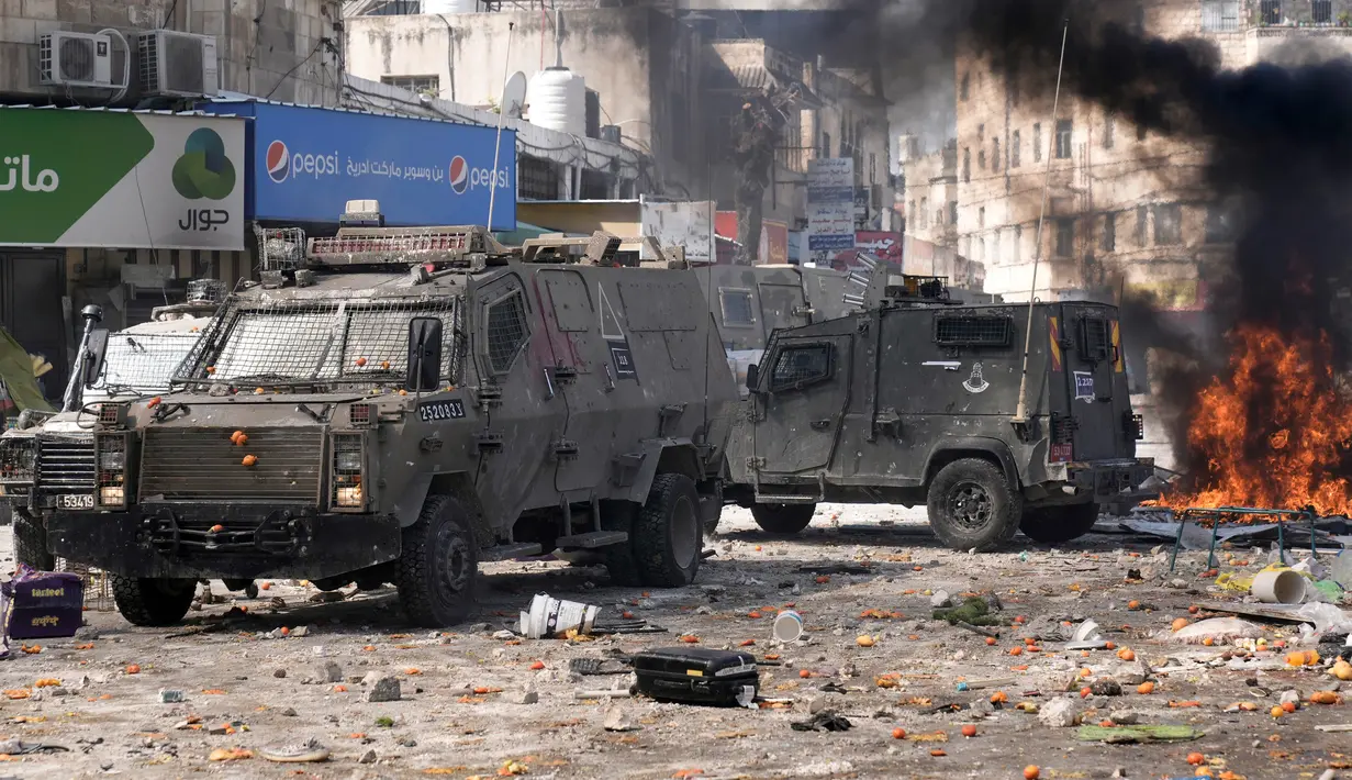 Asap dari api memenuhi udara saat warga Palestina bentrok dengan pasukan Israel di Kota Nablus, Tepi Barat, 22 Februari 2023. Tentara memblokir semua pintu masuk ke kota sebelum mengelilingi sebuah rumah dengan dua pejuang Palestina yang dicari, Hossam Isleem dan Mohammad Abdulghani, di mana keduanya tewas. (AP Photo/Majdi Mohammed)