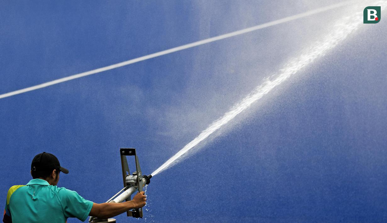 Ofisial mengarahkan pompa air ke lapangan hoki agar permukaan lapangan tidak kering pada laga Asian Games di Lapangan Hoki, GBK, Jakarta, Sabtu (25/8/2018). Indonesia kalah 0-2 dari Thailand. (Bola.com/Peksi Cahyo)