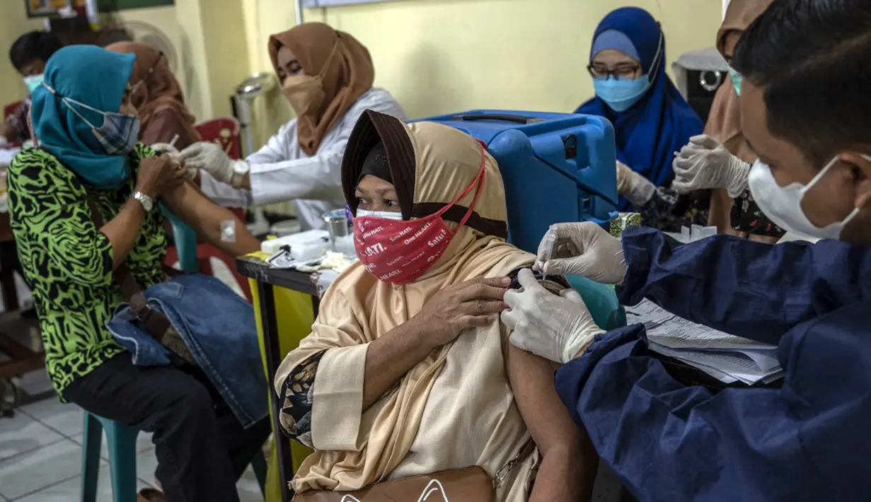 Warga menerima dosis vaksin booster COVID-19 Pfizer di Surabaya, Jawa Timur, Kamis (13/1/2022). (JUNI KRISWANTO/AFP)