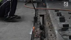 Para pekerja memperbaiki aspal di flyover Kemayoran yang mengalami kerenggangan, Jakarta, Sabtu (5/1). Hal itu disebabkan rusaknya sambungan celah sambungan alias expansion joint. (Merdeka.com/Imam Buhori)