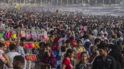 Warga memadati pantai Juhu di Laut Arab pada hari yang panas dan lembab di kota Mumbai, India, 8 Mei 2022. Musim panas yang terik di India menambah risiko baru tahun ini. Suhu di India melebihi 40 derajat Celcius di banyak daerah. (AP Photo/Rafiq Maqbool)