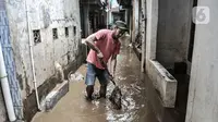 Warga membersihkan lumpur dan sampah saat banjir di permukiman Kebon Pala, Jatinegara, Jakarta, Minggu (25/10/2020). Hampir 12 jam banjir kiriman dari Bogor itu masih merendam permukiman warga di RT 11 RW 05 Kebon Pala dengan ketinggian mencapai pinggang orang dewasa.  (merdeka.com/Iqbal Nugroho)