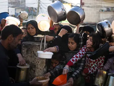 Warga Palestina mengantre untuk mendapatkan makanan gratis di Rafah, Jalur Gaza, pada Selasa, 12 Maret 2024. (AP Photo/Fatima Shbair)