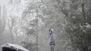 Seorang pria berdiri saat salju turun di Taman Retiro di pusat kota Madrid (7/1/2021). Wilayah timur Castilla-La Mancha, wilayah Madrid dapat melihat timbunan salju dengan total antara 20 dan 50 sentimeter. (AFP/Gabriel Bouys)