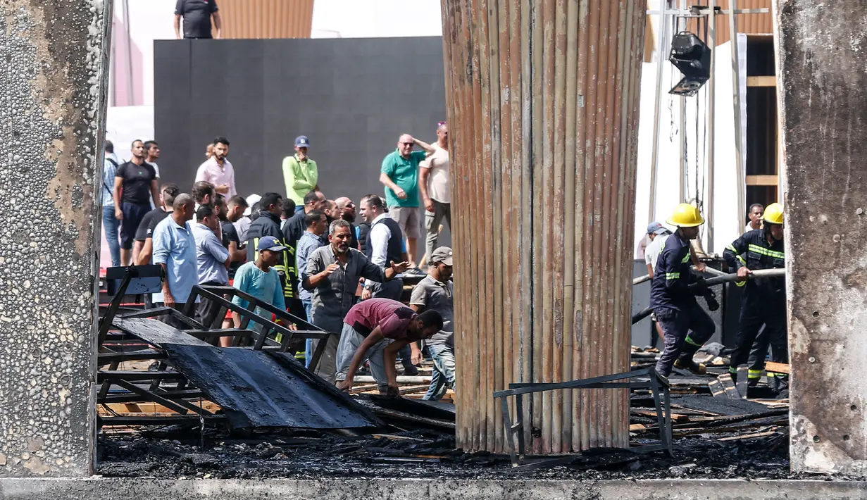 Petugas saat memadamkan kebakaran di paviliun utama situs Festival Film El Gouna yang hangus terbakar di pantai Laut Merah Mesir (12/10/2021). Kobaran api melalap aula utama festival, hanya sehari sebelum acara dimulai, seperti dilansir ArabNews. (AFP)