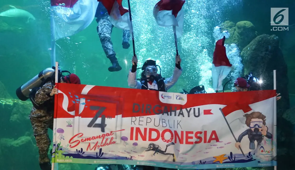 Penyelam melakukan upacara pengibaran bendera di Aquarium Utama Sea World Ancol, Jakarta, Senin (12/8/2019). Pengibaran bendera diadakan dalam rangka menyambut HUT ke-74 RI pada 17 Agustus mendatang. (Liputan6.com/Immanuel Antonius)
