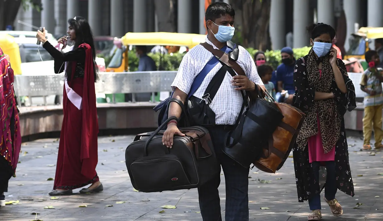 Seorang pedagang membawa tas untuk dijual di pusat perbelanjaan di New Delhi (16/9/2020). Total kasus Covid-19 di India melampaui lima juta pada 16 September, data kementerian kesehatan menunjukkan Pandemi meluas cengkeramannya di negara tersebut. (AFP/Sajjad Hussan)