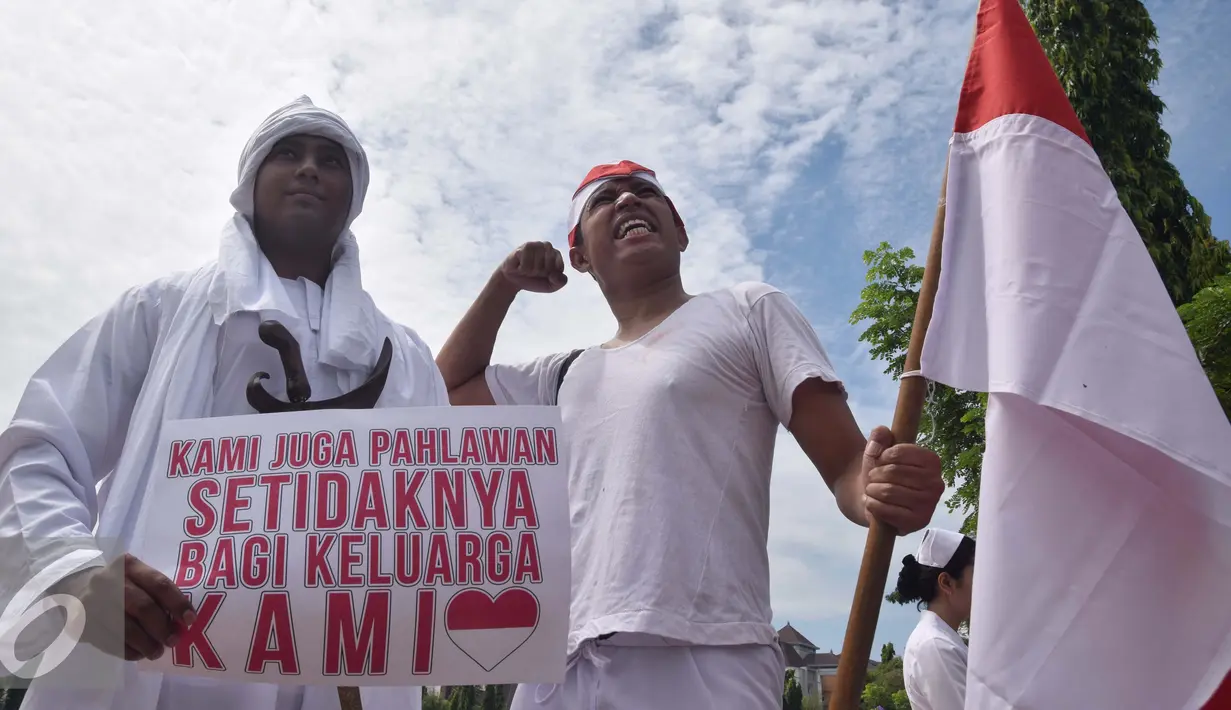 Peserta membawa poster dan bendera merah putih serta mengenakan baju pejuang yang menyerupai tokoh pahlawan saat memperingati Hari Pahlawan di Lapangan Simpanglima, Semarang, Kamis (10/11). (Liputan6.com/Gholib) 