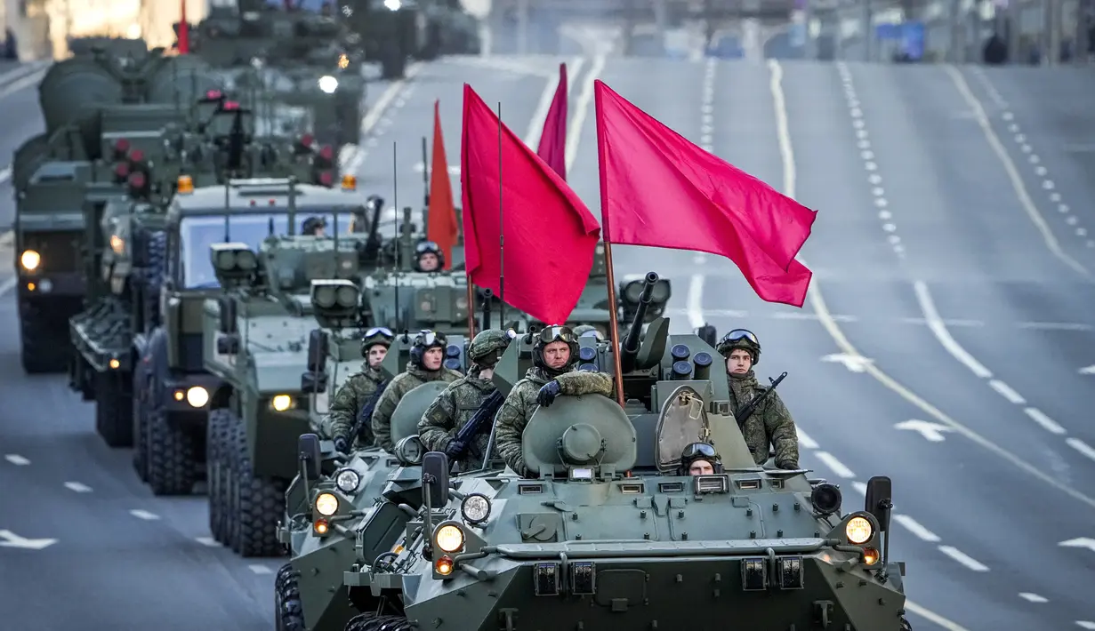 <p>Kendaraan lapis baja Rusia yang dihiasi bendera merah melintasi sepanjang jalan Tverskaya menuju Lapangan Merah untuk menghadiri latihan parade militer Hari Kemenangan di Moskow, Rusia, Rabu (4/5/2022). Pawai akan berlangsung pada Mei 9 untuk merayakan 77 tahun kemenangan dalam Perang Dunia II. (AP Photo/Alexander Zemlanichenko)</p>