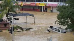 Seorang terdampar menunggu penyelamatan di Hulu Langat, luar Kuala Lumpur, Malaysia, Minggu (19/12/2021). Kuala Lumpur dan perkampungan sekitarnya dilanda banjir akibat hujan deras selama dua hari, menyebabkan ribuan warga mengungsi dan banyak jalan yang memutus akses. (Foto AP/Vincent Thian)