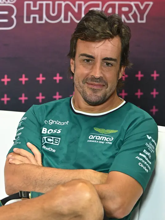 Pembalap Aston Martin asal Spanyol, Fernando Alonso menyaksikan sesi konferensi pers di lintasan balap Hungaroring, Mogyorod, dekat Budapest, 18 Juli 2024, menjelang Grand Prix Formula Satu Hongaria. (ATTILA KISBENEDEK/AFP)