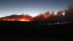 Kebakaran hutan yang membakar memancarkan cahaya di atas lingkungan di pinggiran Flagstaff, Arizona, Minggu (12/6/2022). Evakuasi telah diperintahkan untuk rumah-rumah di daerah tersebut. Pihak berwenang mengatakan petugas pemadam kebakaran menanggapi kebakaran hutan sekitar enam mil di utara Flagstaff yang telah memaksa evakuasi. (AP Photo/Felicia Fonseca)