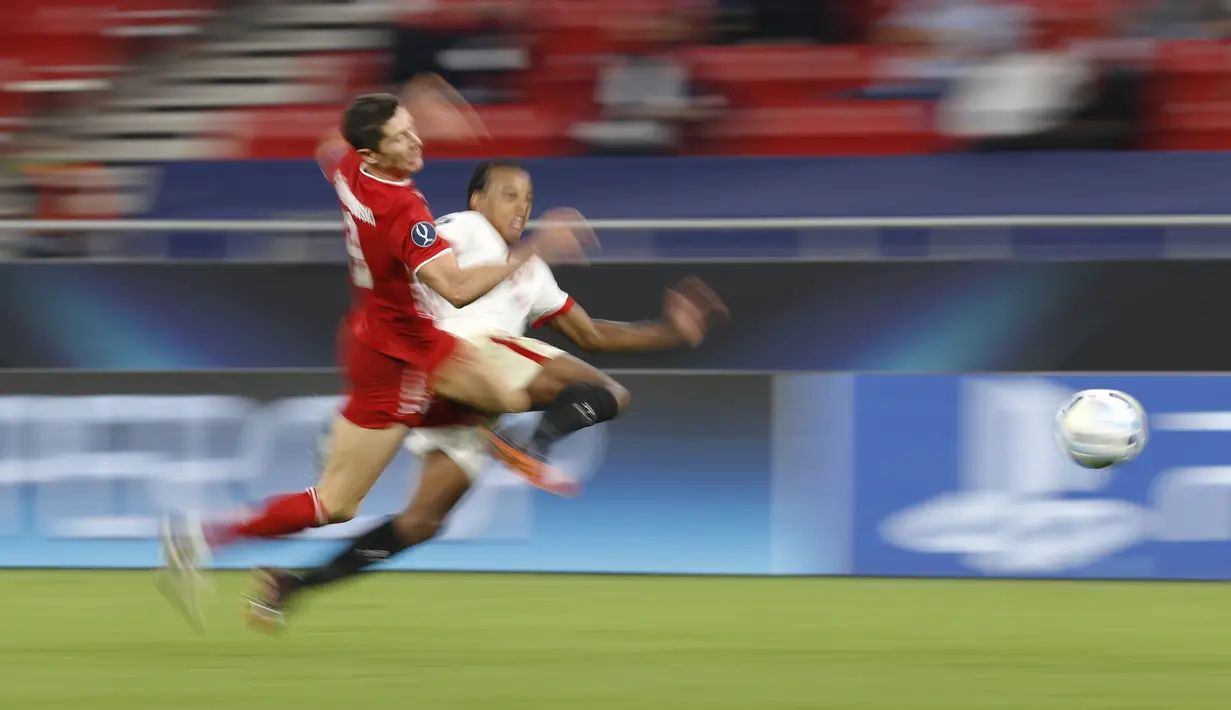Penyerang Bayern Munchen, Robert Lewandowski membawa bola dari kejaran pemain Sevilla, Fernando pada pertandingan Piala Super Eropa di Budapest, Hongaria, Kamis (24/9/2020). Munchen menang tipis 2-1 atas Sevilla. (AP Photo/Laszlo Balogh)