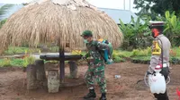 Personel TNI-Polri menyemprotkan disinfektan di Kampung Sota, Distrik Sota, Kabupaten Merauke, Papua, Selasa (24/3/2020). (Puspen Mabes TNI)