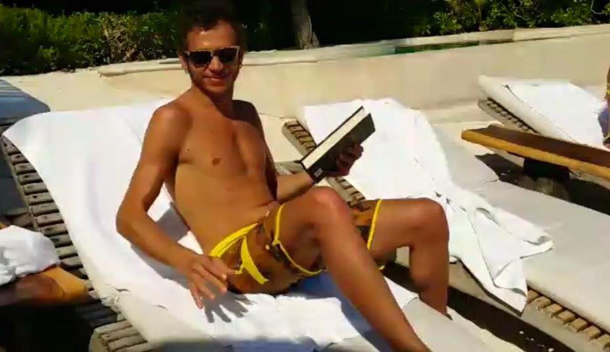 Valentino Rossi berjemur sambil membaca buku di salah satu pantai di Meksiko. (Facebook)