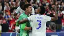 Kiper Real Madrid, Thibaut Courtois (tengah) melakukan selebrasi bersama rekannya usai berhasil melakukan penyelamatan saat laga final Liga Champions antara Liverpool melawan Real Madrid yang berlangsung di Stade de France, Saint Denis, Sabtu, 28 Mei 2022 waktu setempat. (AP/Petr David Josek)