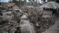Rumah-rumah rusak akibat erupsi Gunung Semeru terlihat di Desa Sumber Wuluh, Lumajang, Jawa Timur, Senin (6/12/2021). Desa Sumber Wuluh luluh lantak diterjang erupsi Semeru mengakibatkan puluhan rumah rusak dan ratusan warga mengungsi. (Juni Kriswanto/AFP)