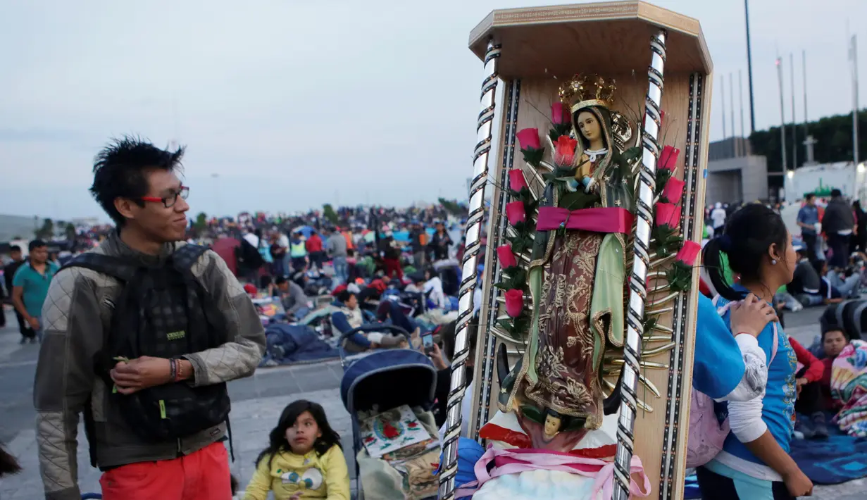 Seorang peziarah membawa patung Bunda dari Guadalupe saat mereka tiba di kawasan Basilika Guadalupe di Mexico City, Meksiko (11/12). (Reuters/Henry Romero)