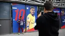 uporter berpose dengan jersey Neymar Jr di depan toko Paris Saint Germain di Paris (4/8). Setelah diumumkan PSG, toko-toko merchandise mulai menjual jersey eks pemain Barcelona tersebut. (AP Photo/Michel Euler)