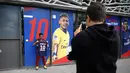 uporter berpose dengan jersey Neymar Jr di depan toko Paris Saint Germain di Paris (4/8). Setelah diumumkan PSG, toko-toko merchandise mulai menjual jersey eks pemain Barcelona tersebut. (AP Photo/Michel Euler)