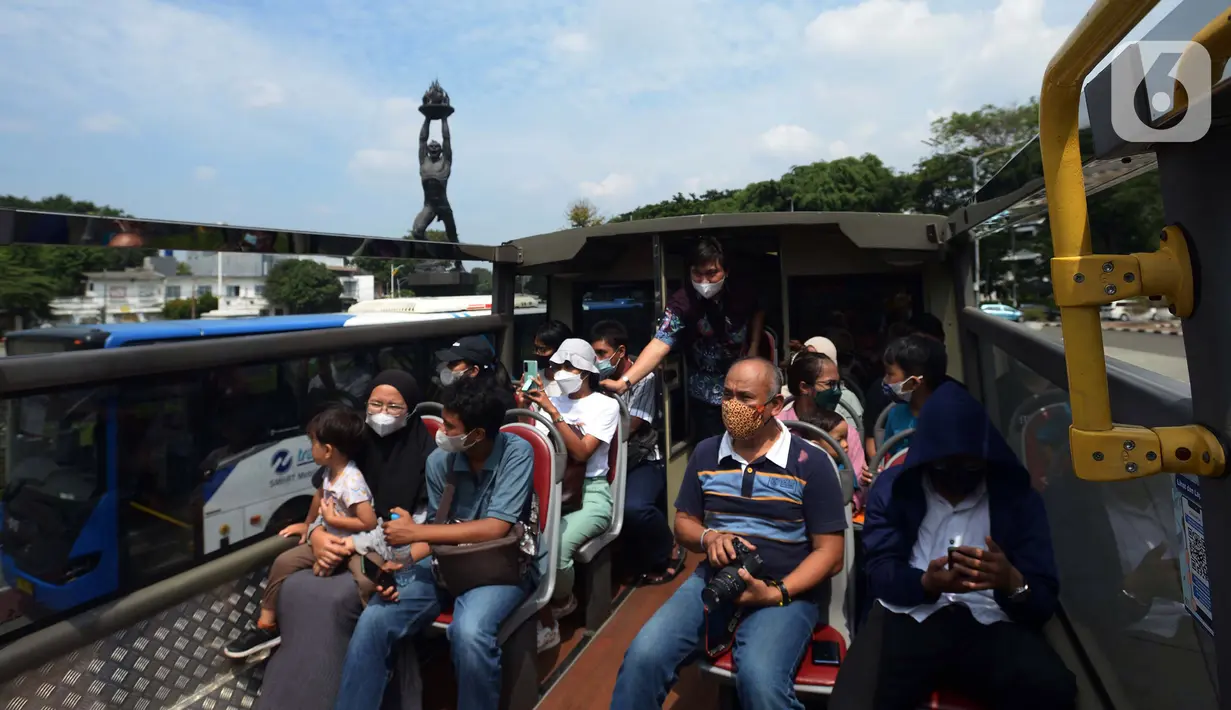 <p>Warga menaiki bus tingkat Transjakarta dengan atap terbuka di Jakarta, Selasa (10/5/2022). Selama libur Lebaran, bus wisata tersebut melayani warga menuju berbagai rute destinasi wisata Ibu Kota. (merdeka.com/Imam Buhori)</p>