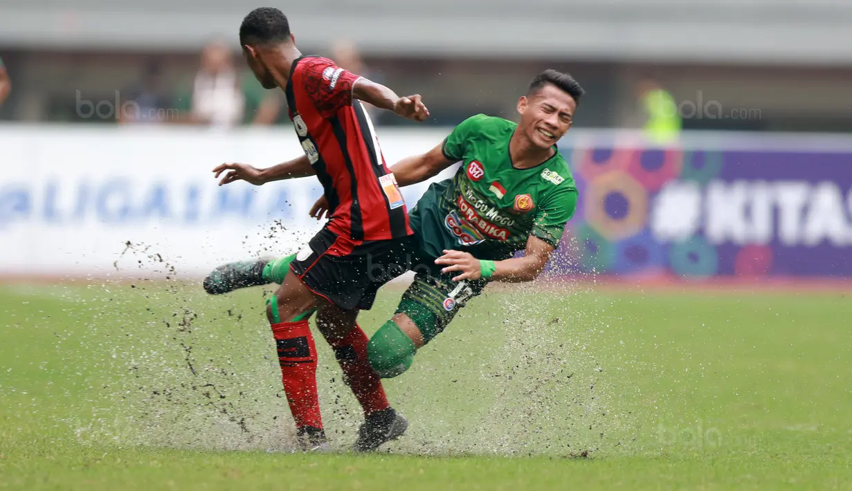 Pemain Persipura Jayapura, Ruben Sanadi (kiri) berebut bola dengan pemain PS TNI, Ahamd Noviandani pada lanjutan Liga 1 2017 di Stadion Patriot, Bekasi (4/11/2017). PS TNI menang 2-1.  (Bola.com/Nick Hanoatubun)