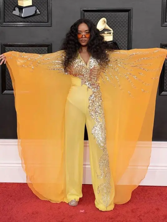 Membawa pulang piala Grammy untuk kategori Best Traditional R&B Performance, penampilan penyanyi multitalenta H.E.R membawa berbalut jumpsuit kuning juga tak kalah mencuri perhatian. (Instagram/enricoagus).