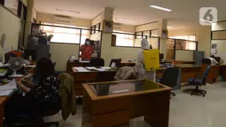 Petugas menyemprotkan cairan disinfektan di ruang kerja dan ruang pelayanan Suku Dinas Sosial Jakarta Timur, Jumat (18/2/2022). Sebanyak 6 orang yang terpapar Covid-19 sedang menjalani isolasi di rumah, sementara pelayanan ditutup selama tiga hari. (merdeka.com/Imam Buhori)