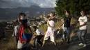 Para pemuda menerbangkan layang-layang dalam acara peringatan 400 tahun permukiman kumuh Petare di Caracas, Venezuela (17/2/2021). Kemiskinan tetap menjadi kendala utama perkembangan kota ini. (AP Photo/Ariana Cubillos)