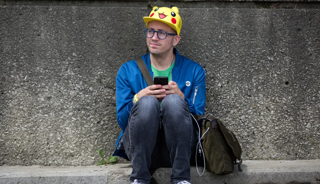 Ekspresi pria asal Los Angeles saat duduk menepi dalam Festival Pokemon Go, di Giant Park, Chicago, Sabtu (22/7). Diperkirakan terdapat 20.000 peserta yang hadir dalam peluncuran produk terbaru dari Pokemon Go. (AP/Erin Hooley)