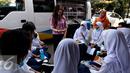 Sekjen Komisi Perlindungan Anak (KPAI) Erlinda menghibur siswa SMPN 49 Jakarta, Jumat (4/9/2015). Sebelumnya sekolah SMPN 49 mengalami kebakaran dan menyebakan ruangkan perpustakaan ludes terbakar. (Liputan6.com/Yoppy Renato)
