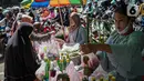 Penjual bunga tabur melayani pembeli di TPU Karet Tengsin, Jakarta, Minggu (27/3/2022). Sebagian warga memanfaatkan waktu jelang Ramadan menjadi penjual bunga tabur musiman untuk memenuhi kebutuhan ziarah ke makam yang dijual Rp 5.000 - Rp 20.000 per kantong plastik. (Liputan6.com/Faizal Fanani)