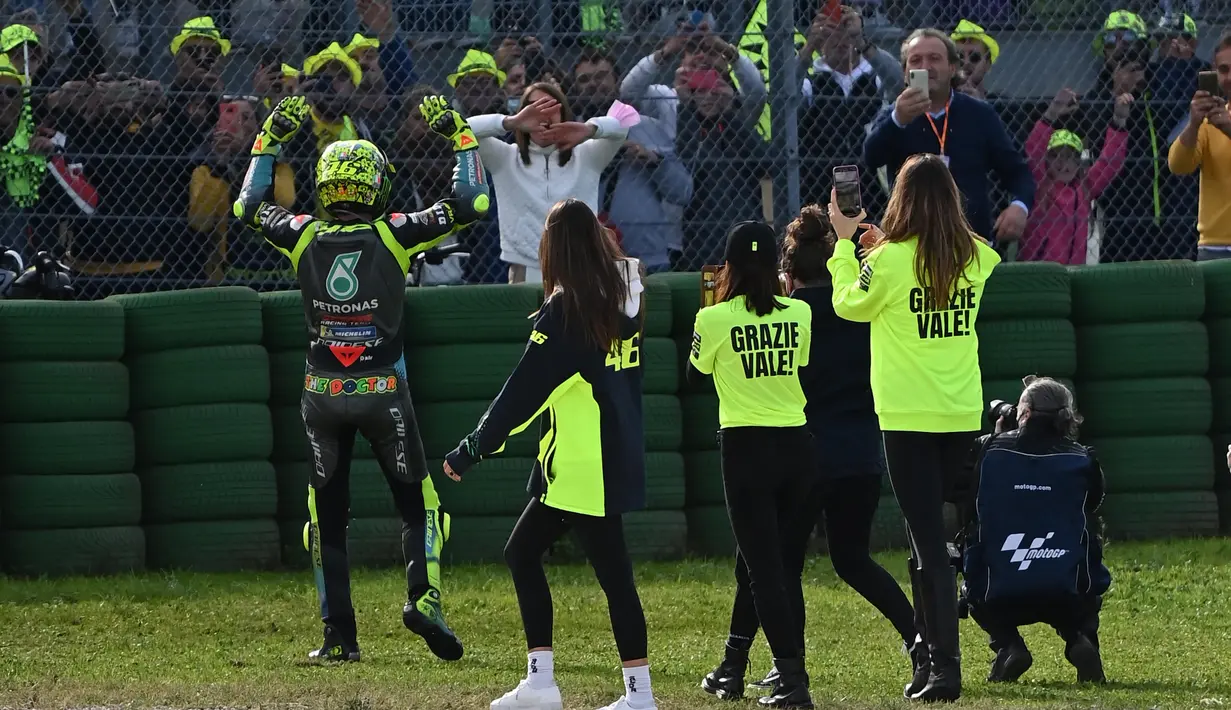 Rossi mengucapkan terima kasih atas dukungan dengan melambaikan tangan. Juara dunia Grand Prix sembilan kali itu kemudian naik ke tumpukan ban yang berada di depannya. (AFP/Andreas Solaro)