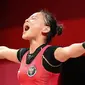 Lifter Indonesia Windy Cantika Aisah meluapkan kegembiraan saat bertanding pada cabang angkat besi 49kg putri Olimpiade Tokyo 2020 di Tokyo International Forum, Sabtu, 24 Juli 2021. (Vincenzo PINTO / AFP)