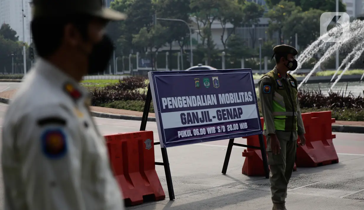 Petugas gabungan melakukan penyekatan di pos penyekatan ganjil-genap di Bundaran Senayan, Minggu (5/9/2021). Pembatasan kendaraan dengan sistem pelat nomor kendaraan ini tetap berlaku di akhir pekan, Sabtu dan Minggu. (Liputan6.com/Angga Yuniar)