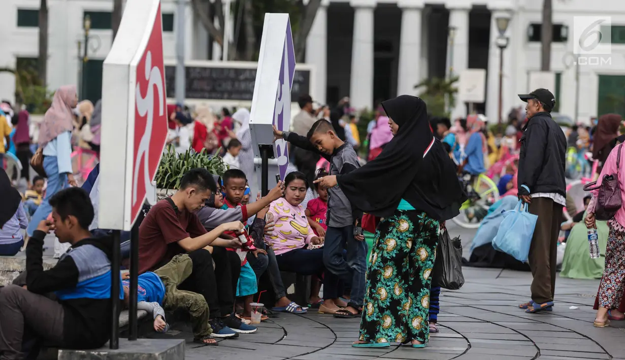 Sejumlah warga berwisata di Kawasan Kota Tua, Jakarta, Selasa (26/12). Ribuan pengunjung dari luar kota atau Ibu kota Jakarta memilih untuk menghabiskan waktu dengan cara berkunjung ke Museum Fatahilah. (Liputan6.com/Faizal Fanani)