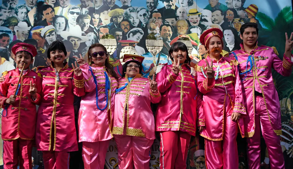 Sejumlah peserta berpose saat berusaha memecahkan rekor dunia "Guinness World Record" dengan jumlah terbesar orang mengenakan pakaian dan bergaya seperti  The Beatles di sebuah taman di Mexico City, Meksiko 28 November 2015. (AFP PHOTO/ALFREDO ESTRELLA)