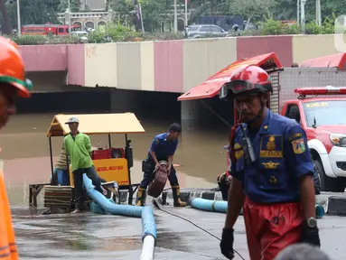 Petugas melakukan penyedotan air yang merendam underpass Kemayoran, Jakarta, Minggu (2/2/2020). Akibat hujan yang cukup lama di kawasan tersebut membuat underpass tersebut terendam air hingga ketinggian 5 meter. (Liputan6.com/Angga Yuniar)