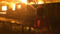 Petugas pemadam kebakaran berusaha memadamkan api yang terjadi di kawasan Rindang Banua atau lebih dikenal dengan Puntun, di Kecamatan Pahandut, Kota Palangkaraya. (foto: Roni Sahala)