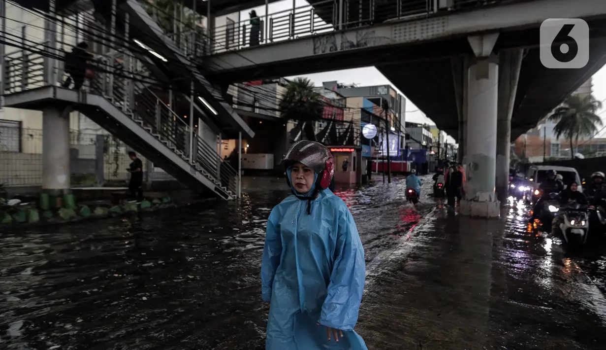 Seorang warga berjalan melintasi banjir yang menggenangi kawasan Seskoal - Cipulir, Jakarta, Selasa (4/4/2022). Hujan yang mengguyur wilayah Ibu Kota Jakarta mengakibatkan banjir menggenangi kawasan Simpang Seskoal, Kebayoran Lama, Jakarta. Banjir setinggi 50cm - 1 meter disebabkan saluran pembuangan berukuran kecil tersumbat. (Liputan6.com/Johan Tallo)