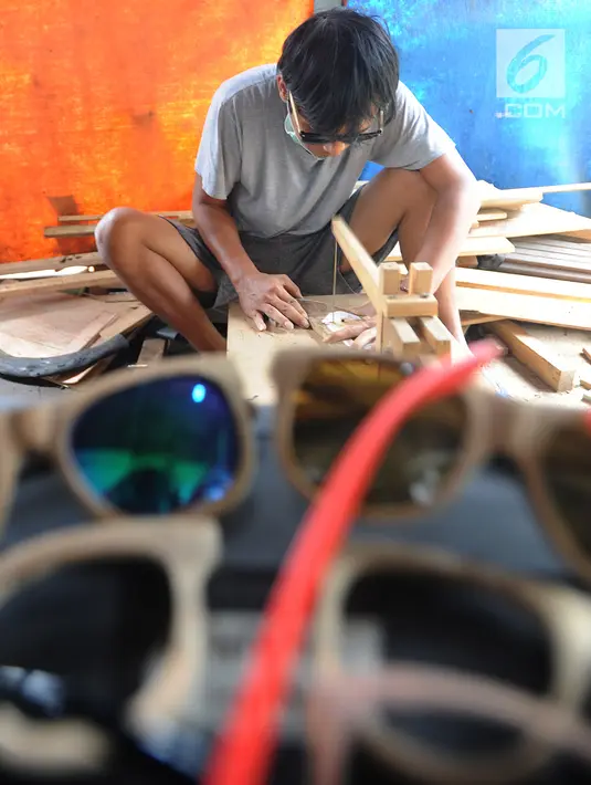 Perajin memproduksi kacamata berbahan baku kayu di Gang  Madrasah, Pamulang, Tangerang Selatan, Senin (21/1). Dalam sehari, pengrajin mampu menyelesaikan dua buah kacamata yang dijual Rp 200 ribu hingga Rp 500 ribu per buah. (Merdeka.com/Arie Basuki)