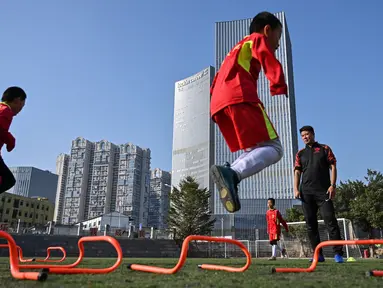 Mantan penyerang Manchester United asal China, Dong Fangzhuo (kanan) saat melatih anak-anak di Xiamen di provinsi Fujian, China (10/12/2019). Dong Fangzhuo yang kini berusia 34 tahun melatih anak-anak di China, beberapa di antaranya berkebutuhan khusus. (AFP/Hector Retamal)
